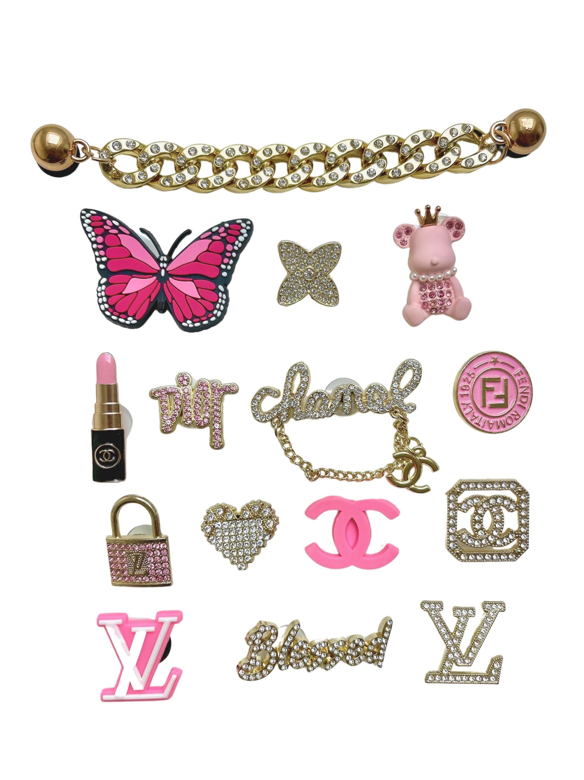 Les 15 charms du set "Pink Era" disposés à plat sur fond blanc