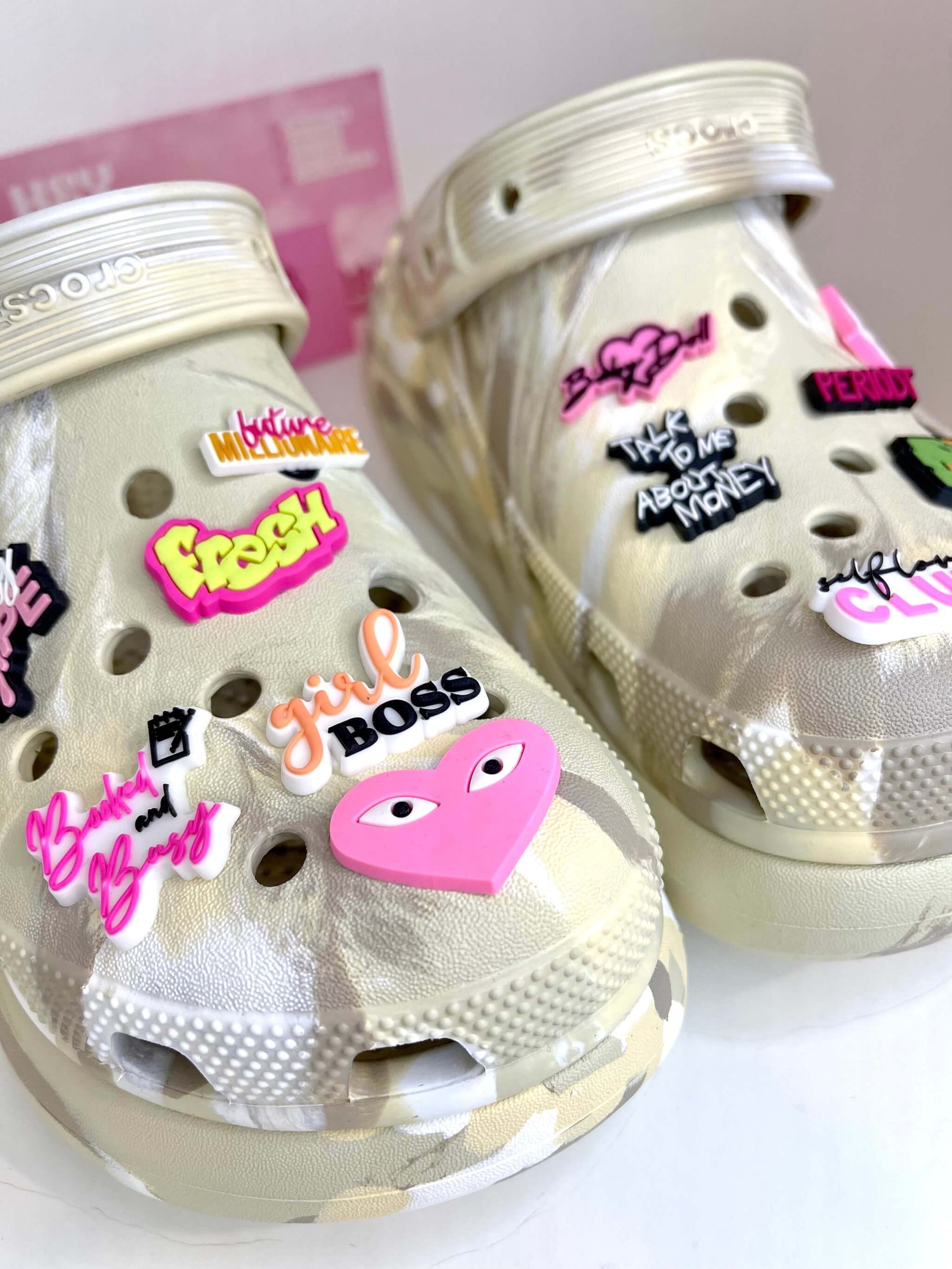 Paire de Crocs beige à plateforme personnalisée avec les charms du set "Boss babe", vue de près